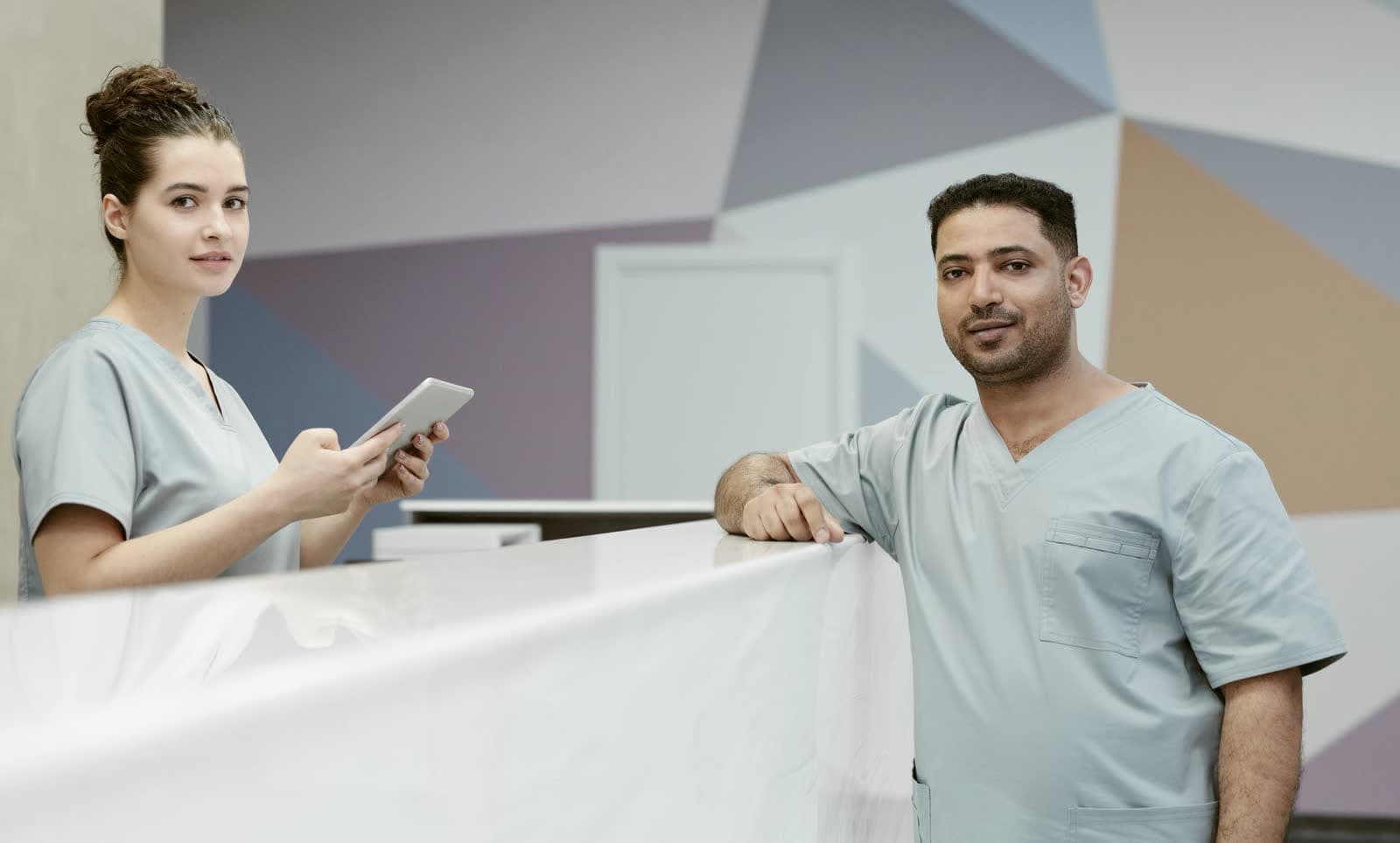 Two people at a clinic reception desk