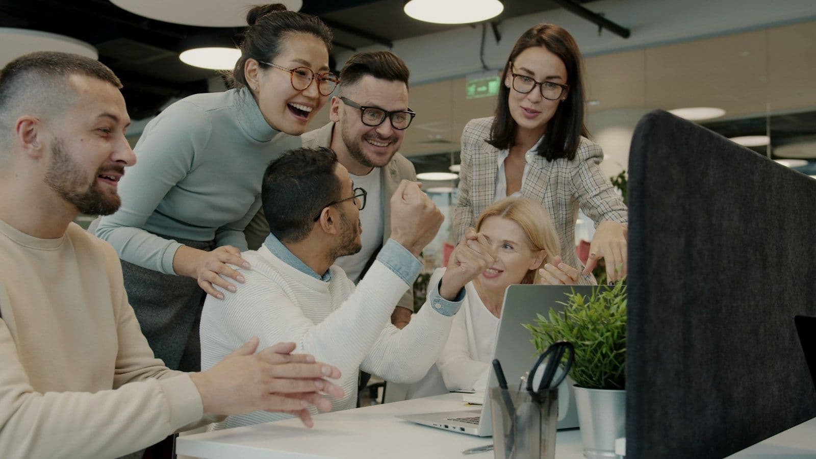 A support team celebrating together at a desk