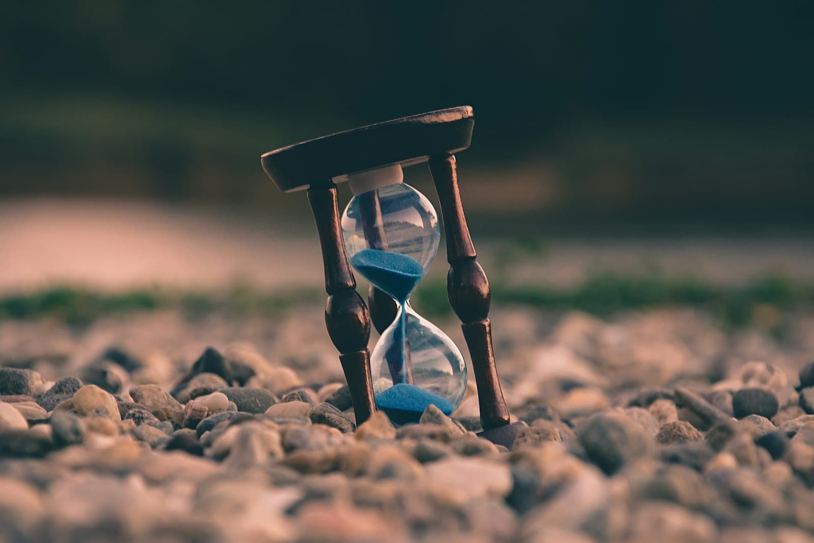 An hourglass standing on a bed of pebbles